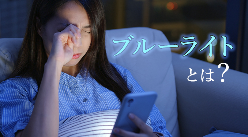 夜スマホを見て目をこする女性